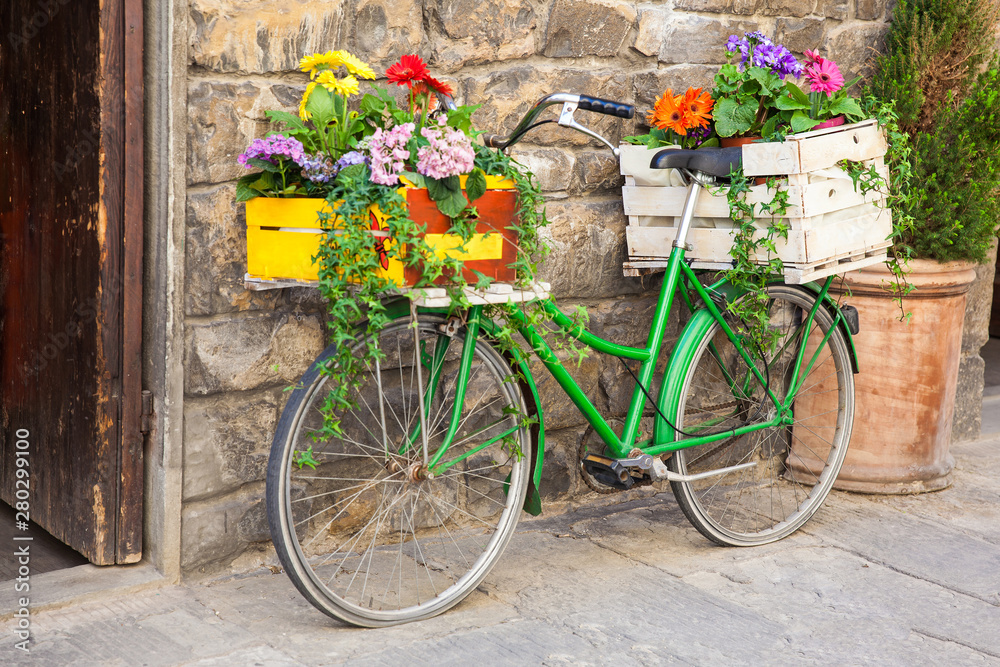 Green bicycle decorated with flowers parked in Florence