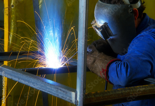 A steel welder welding a square pipe