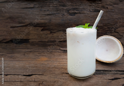 Coconut smoothies white fruit juice milkshake blend beverage healthy high protein the taste yummy In glass drink episode morning on a wooden background.