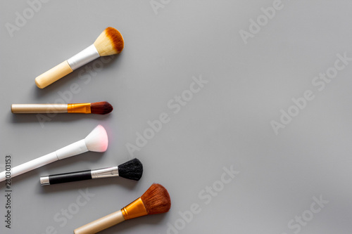 Brushes for make up on gray visagiste work desk background top view copyspace photo