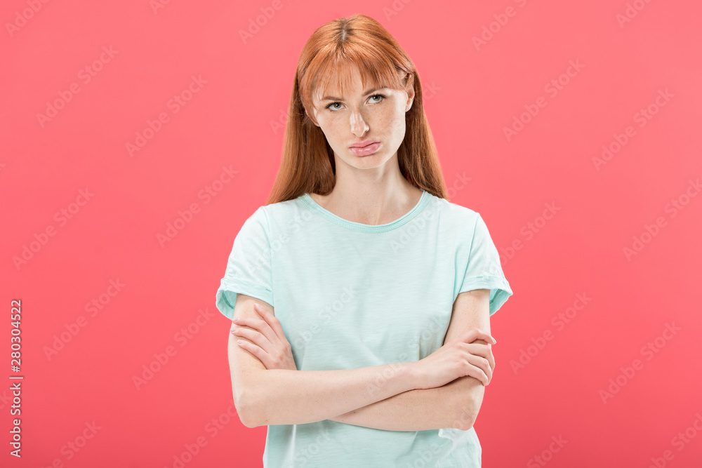 front view of pensive redhead young woman in t-shirt standing with crossed arms isolated on pink front view of pensive redhead young woman in t-shirt standing with crossed arms isolated on pink