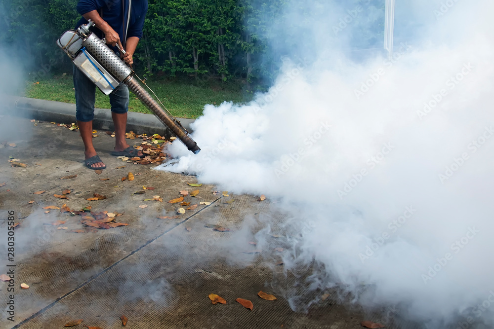 Staff are injecting chemicals to get rid of the mosquitoes in the drain.  Asian men are spraying smoke to destroy the origin of dengue fever.