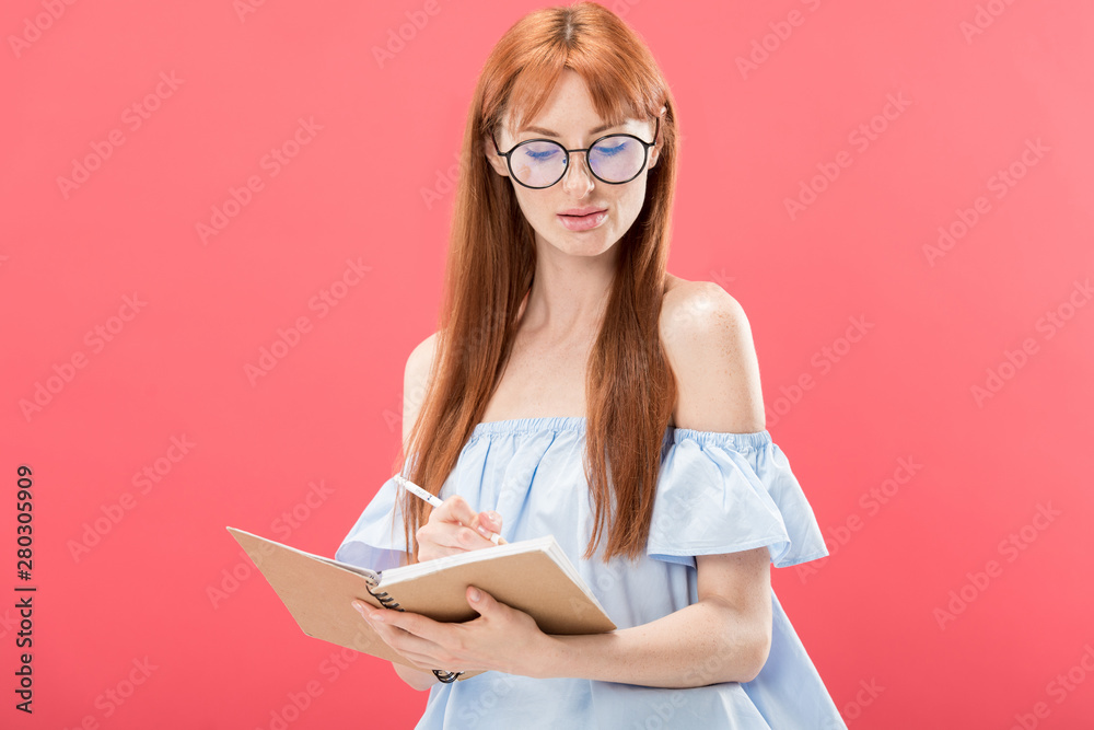 attractive redhead woman in glasses holding pencil and textbook isolated on pink attractive redhead woman in glasses holding pencil and textbook isolated on pink