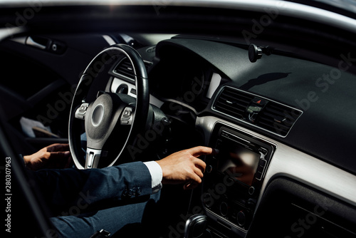 cropped view of african american businessman in suit pushing button in car © LIGHTFIELD STUDIOS