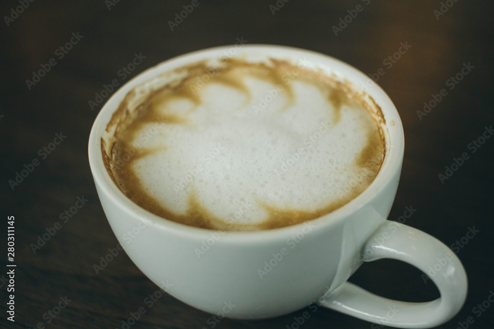 Coffee cup and coffee beans on wooden table  in cafe