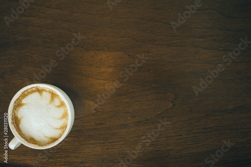 Coffee cup and coffee beans on wooden table in cafe