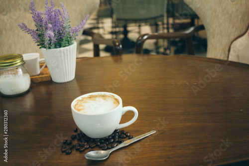 Coffee cup and coffee beans on wooden table  in cafe