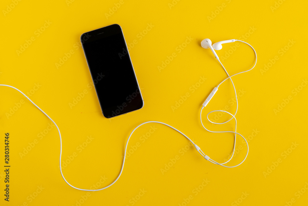 Obraz premium flat lay of modern music player device and earphones, minimalistic concept on color surface