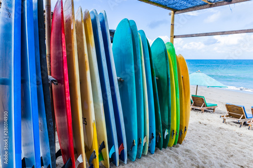 Surfboards of different color and size  are standing on the beach in Bali