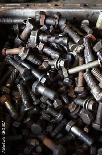 Blurred close up of old steel nuts and bolts in tool box