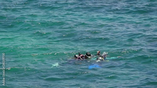 Keelung, Taiwan-16 July, 2019: Slow Motion of people in diving gear dives up to water surface. Swimming in the blue ocean with scuba diver's equipment at summer vacation of a tropical island.-Dan photo