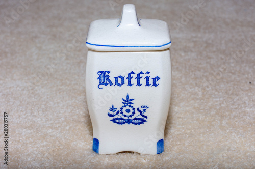 Delft Blue Coffee (Koffie) container. Famous porcelain souvenirs from Holland/Netherlands. Isolated on textured beige background. photo