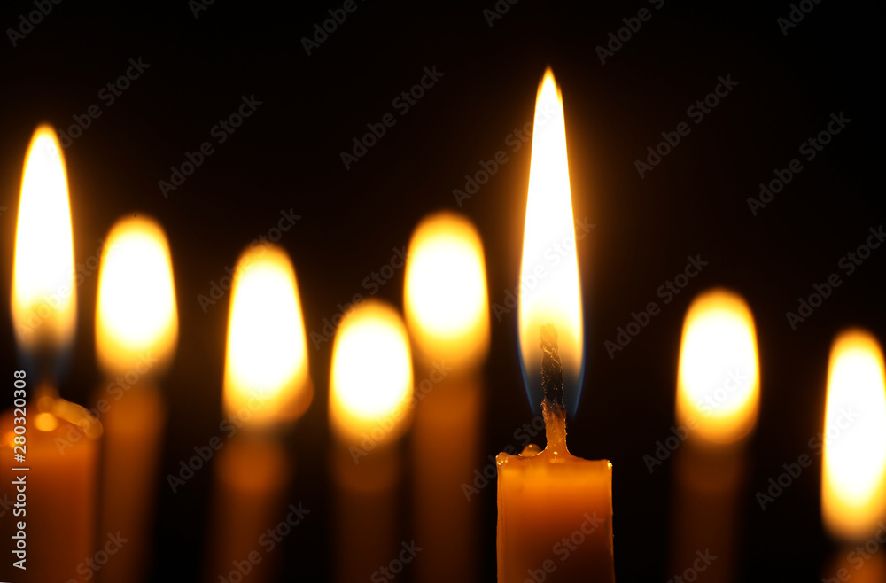 Burning candles on dark background, space for text. Symbol of sorrow Burning candles on dark background, space for text. Symbol of sorrow