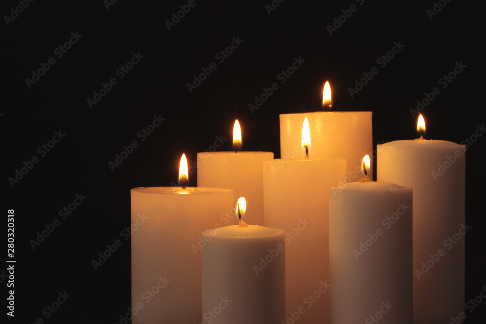 Burning candles on dark background, space for text. Symbol of sorrow Burning candles on dark background, space for text. Symbol of sorrow