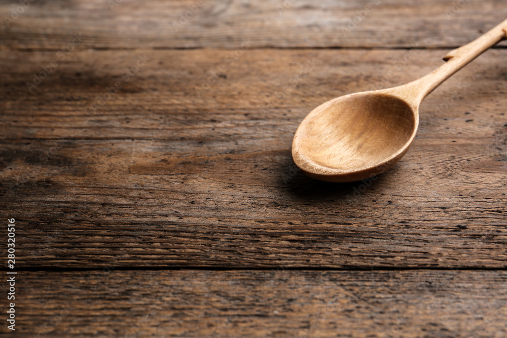 Clean empty spoon on wooden background, space for text Clean empty spoon on wooden background, space for text
