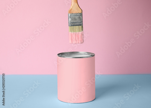 Fototapeta Naklejka Na Ścianę i Meble -  Brush over can of pink paint on blue table