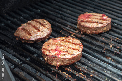 summer close up beef hamburger BBQ on a propane gas grill