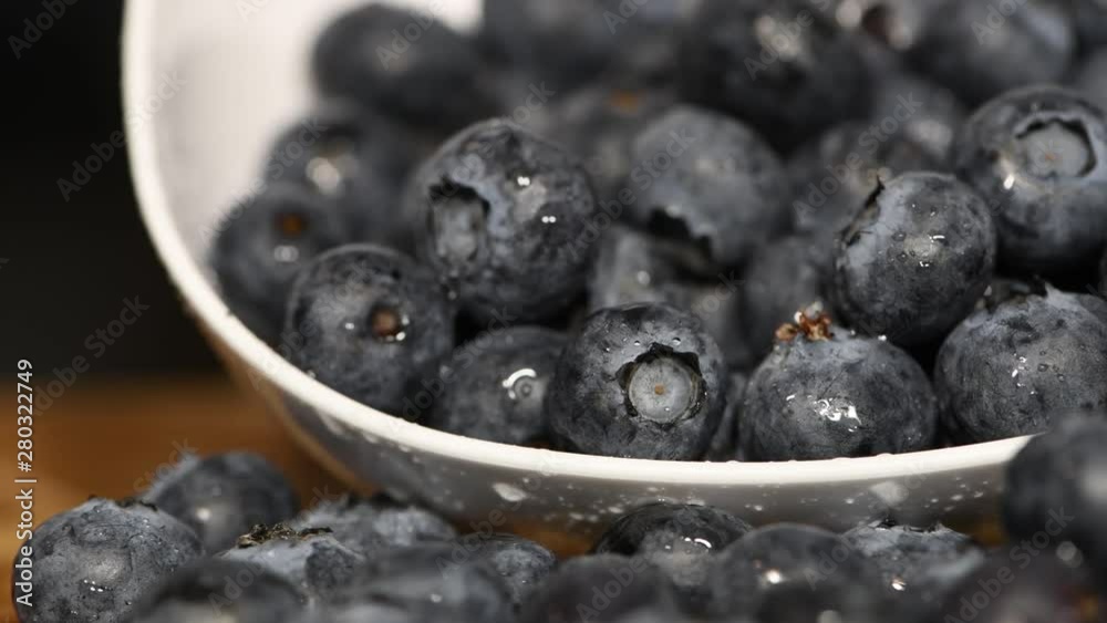 A full bowl of fresh ripe blueberries offering itself an old wooden table. Slow pan movement on slider. A full bowl of fresh ripe blueberries offering itself an old wooden table. Slow pan movement on slider.