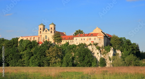 Landscape with medieval benedictine abbey in tyniec nearby Krakow, Poland, built on rocky hill on Vistula river bank, field and thick greenery around