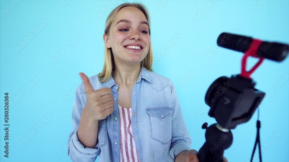 Beautiful girl blogger relieves itself at camera isolated blue background Beautiful girl blogger relieves itself at camera isolated blue background