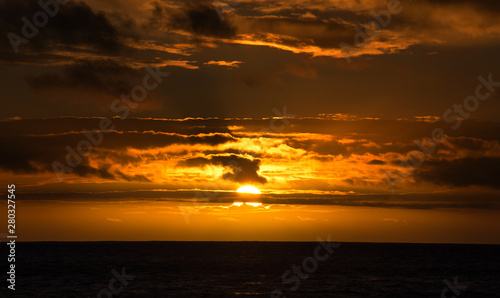 Beautiful sunset on the ocean with cloudy dramatic sky background
