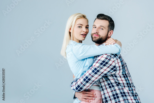 beautiful young couple embracing isolated on grey with copy space