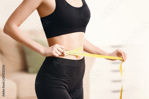 Woman with measuring tape at home. Weight loss concept