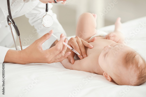 Pediatrician vaccinating li...