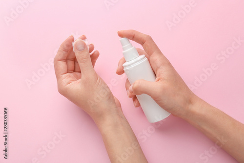 Female hands with cosmetic product on color background