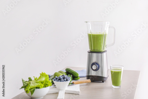 Tableau sur toile Glass of healthy smoothie, blender and ingredients on table