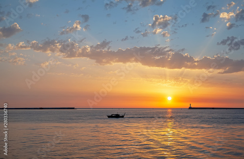 Ship against the sunset sky in the sea.