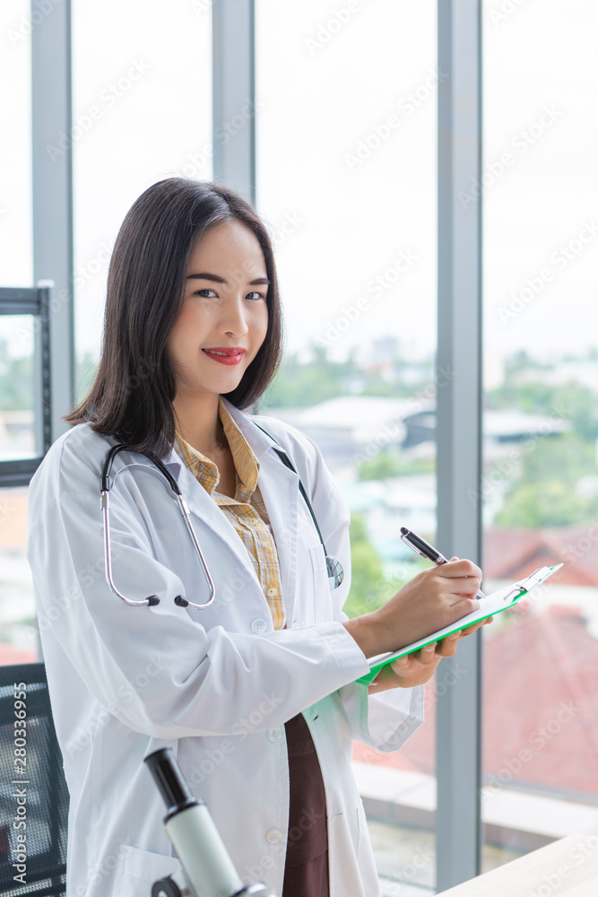 Smiling asian nutritionist doctor woman writing on paper green board in laboratory room