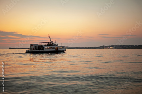 Ship against the sunset sky in the sea.