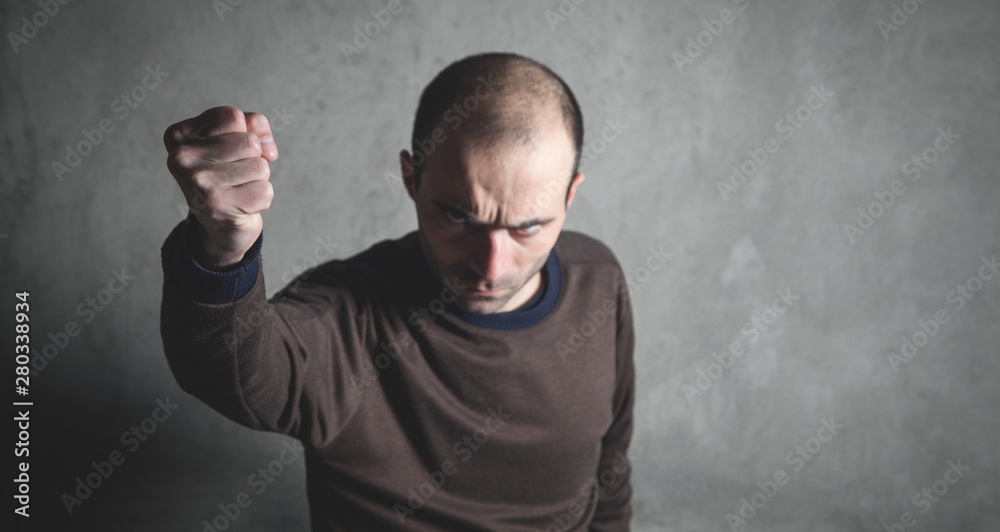 Caucasian angry and aggressive man threatening with fist. Caucasian angry and aggressive man threatening with fist.