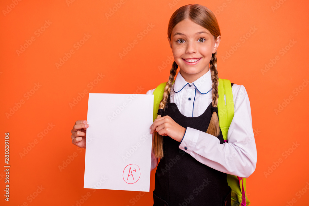 Close-up portrait of her she nice attractive charming cute cheerful cheery confident successful pre-teen girl showing good mark score grade isolated on bright vivid shine orange background Close-up portrait of her she nice attractive charming cute cheerful cheery confident successful pre-teen girl showing good mark score grade isolated on bright vivid shine orange background
