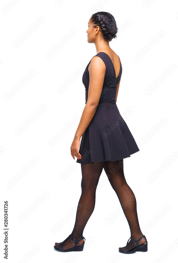 back view of a young black girl walking in jeans and a checkered back view of a young black girl walking in jeans and a checkered