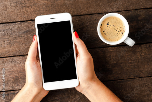 Woman holding white smart phone with copyspace.