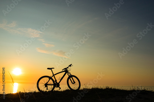 beautiful sunset on the sea and the silhouette of a bicycle © Jekaterina