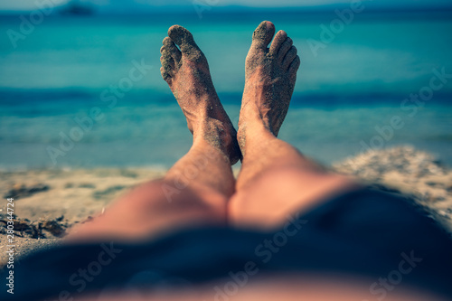 Man lying and enjoying on a sandy tropical beach.