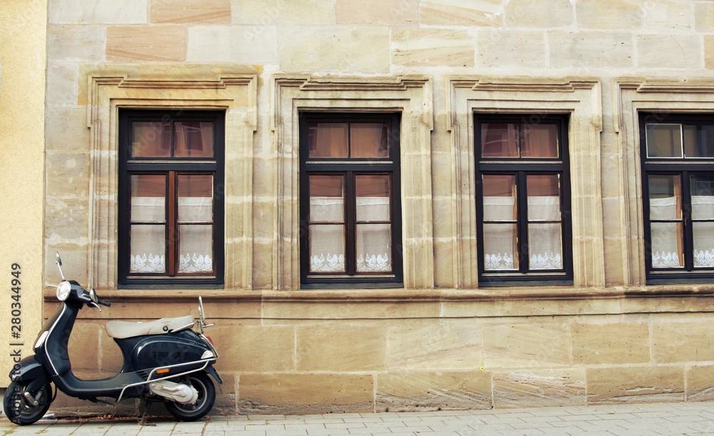 Vintage scooter in front of an old architecture building.