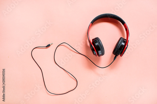 Headphones on pink background with free text space. Music concept.