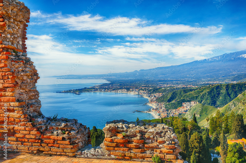 Aquamarine blue waters of sea near Taormina resorts and Etna volcano mount