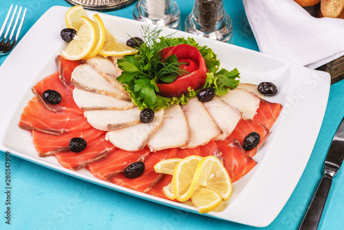  Mediterranean fish sliced ​​salmon, tuna and trout with vegetables, greens, lemon and black olives