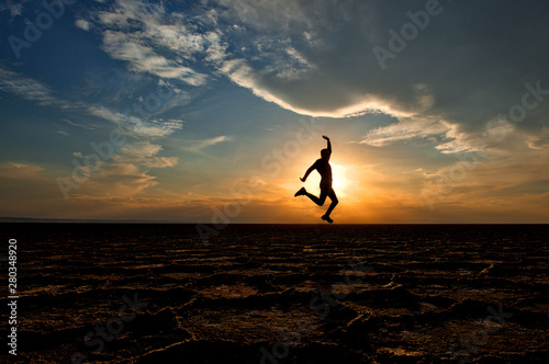 Silhouette of a man jumping in air, Dashte Kavir-Salt Desert National Park, Kashan, Iran photo