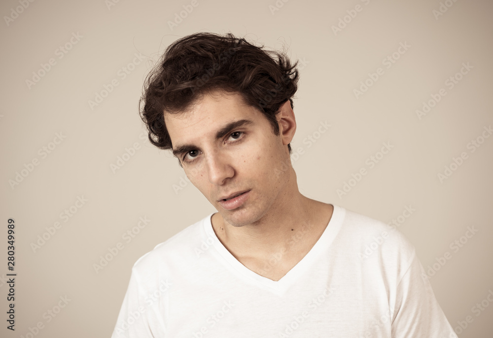 Obraz premium Natural portrait of young attractive man in his 20s looking and posing with neutral face expression