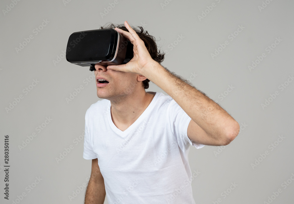 Portrait of cheerful and shocked young man wearing 360 Virtual Reality headset exploring 3D world Portrait of cheerful and shocked young man wearing 360 Virtual Reality headset exploring 3D world