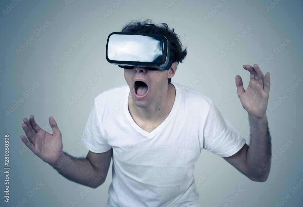 Young man having a scary experience with Virtual Reality goggles shouting in shock Young man having a scary experience with Virtual Reality goggles shouting in shock