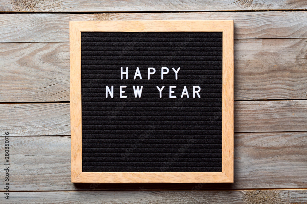 Christmas or new year frame or mockup for your project. Happy new year words on a letter board on wooden background
