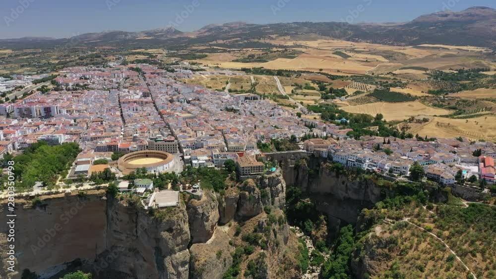 Aerial view of cityscape of Ronda, famous historic city with impressive arch bridge Puente Nuevo over gorge El Tajo - landscape panorama of Andalusia from above, province of Malaga, Spain, Europe Aerial view of cityscape of Ronda, famous historic city with impressive arch bridge Puente Nuevo over gorge El Tajo - landscape panorama of Andalusia from above, province of Malaga, Spain, Europe