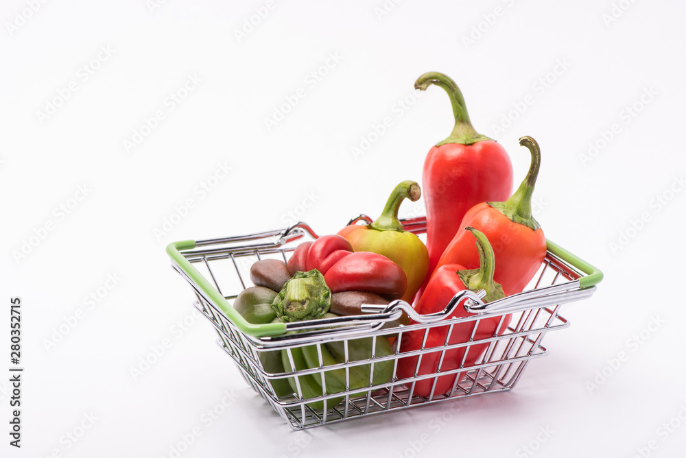 Several ripe sweet and hot peppers of red and orange on a white background